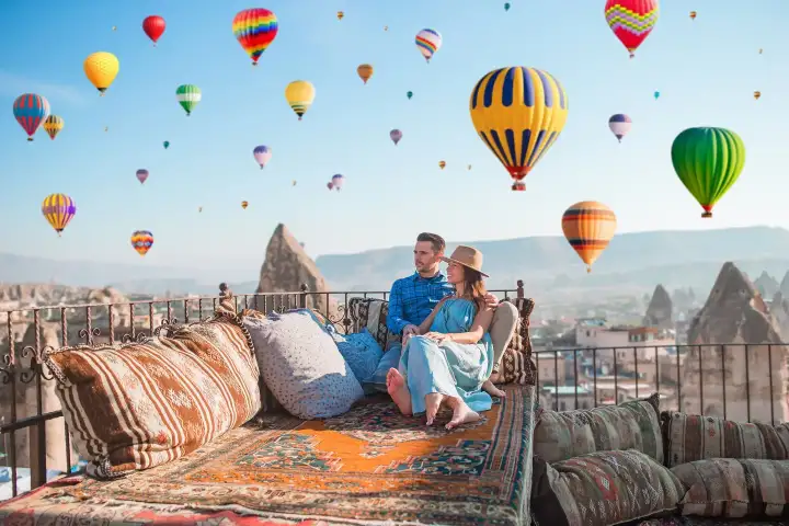 Couple on terrace viewing fairy chimneys and balloons