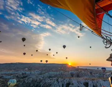Hot air balloon over canyon ridge in Cappadocia