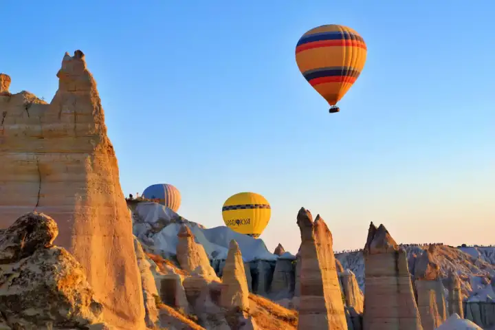 Golden morning light on rising Cappadocia balloons