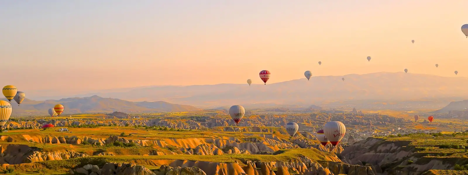 Golden sunset landscape with Cappadocia balloons