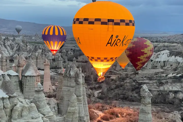 Mongolfiere in Cappadocia sopra valli con camini delle fate