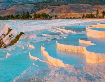 Sunset with orange sky and blue water on Pamukkale terraces