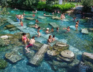 Swimmers in crystal water of Pamukkale Cleopatra Antique Pool