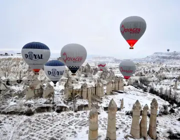 Mongolfiere in Cappadocia all alba sopra valli con camini delle fate