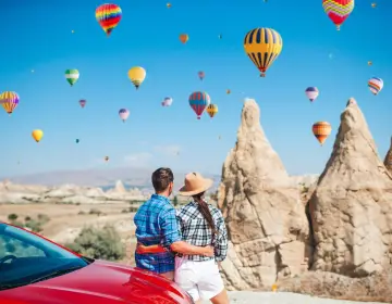 Couple viewing fairy chimneys and hot air balloons