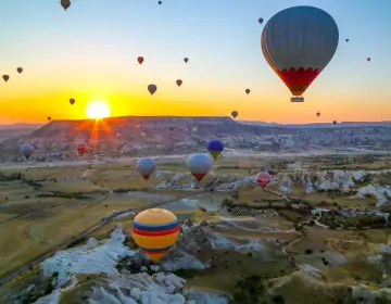 Mongolfiere in Cappadocia all alba sopra valli con camini delle fate
