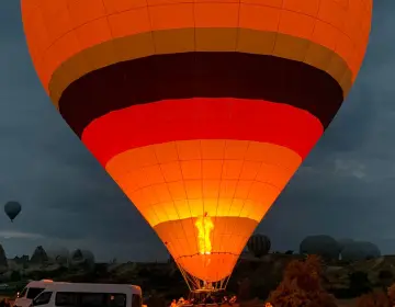 Yellow and red hot air balloon taking off in Cappadocia
